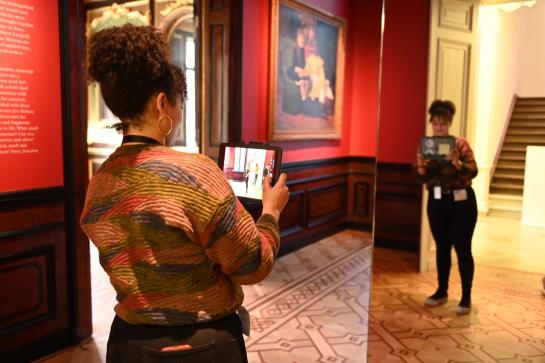 Jonge vrouw met tablet in museum